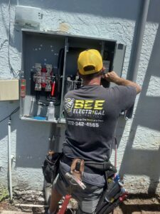 An electrician from Bee Electrical Contracting working on an outdoor electrical panel in Port Saint Lucie, FL.