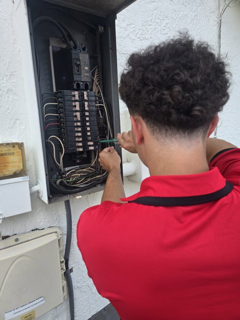 An electrician working on an outdoor electrical panel, providing service for Small Jobs Electric in Tampa, FL.
