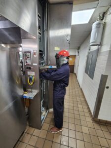 An electrician in full personal protective equipment working on an electrical panel for ALC Electric LLC in Goose Creek, SC