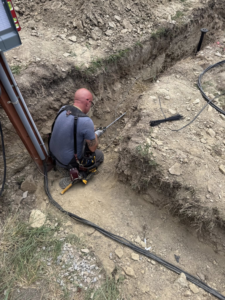 An electrician from Circuit Masters, Inc. working on electrical wiring in a trench in Billings, MT.