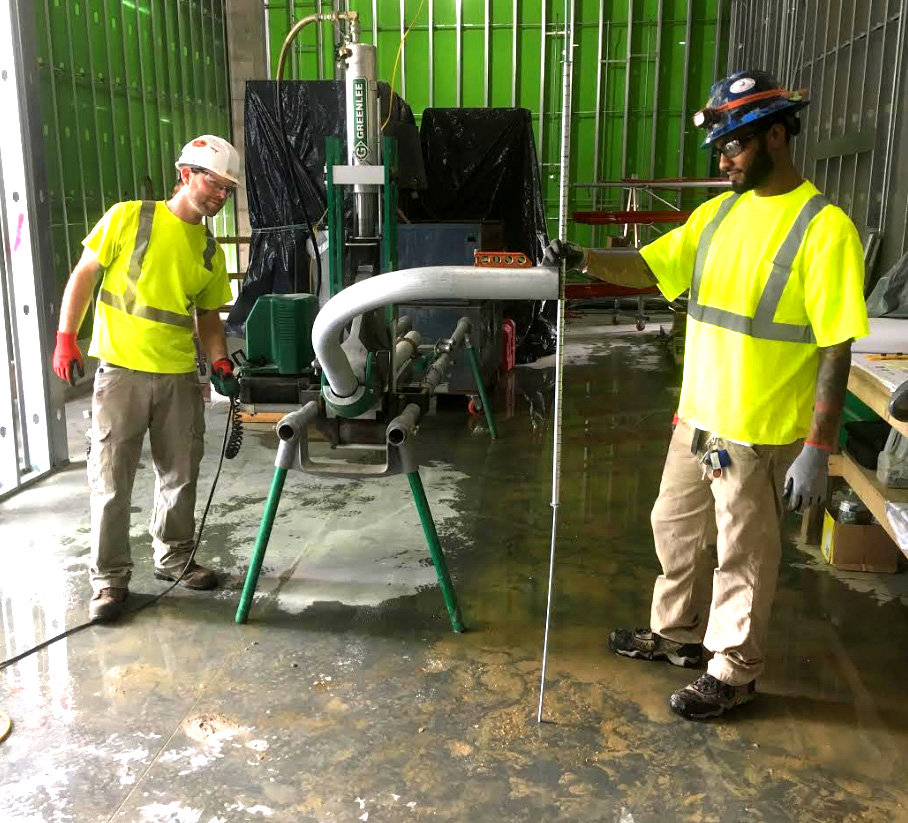Electricians from Bay Electric Co. using a Greenlee conduit bender on a job site in Newport News, VA.