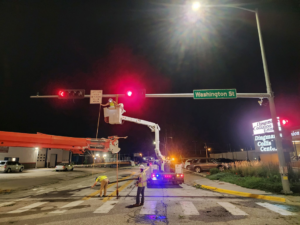 Electricians in a bucket truck repairing traffic lights at night for Vierregger Electric Co. in Omaha, NE.