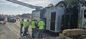 A crew of electricians and a vacuum excavator truck working on a road construction site for TC Electric, Inc in Indianapolis, IN.