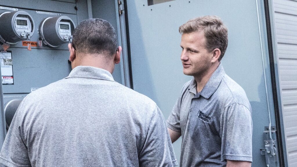 Efficient Electric electricians inspecting an electrical panel with multiple meters in Canton, MI.