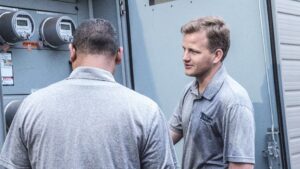 Efficient Electric electricians inspecting an electrical panel with multiple meters in Canton, MI.