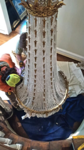 Two electricians installing a large chandelier for Wood Bros. Electric in North Little Rock, AR