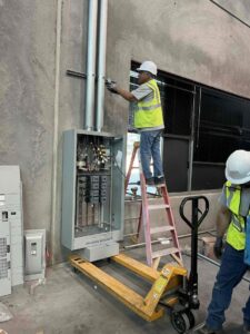 Electricians from Eco Electric installing a commercial electrical panel and conduit in Las Vegas, NV.