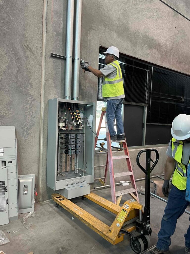 Electricians from Eco Electric installing a commercial electrical panel and conduit in Las Vegas, NV.
