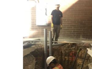 Electricians from High Tech Electric inc. installing electrical conduits in a trench at a job site in Van Nuys, CA.