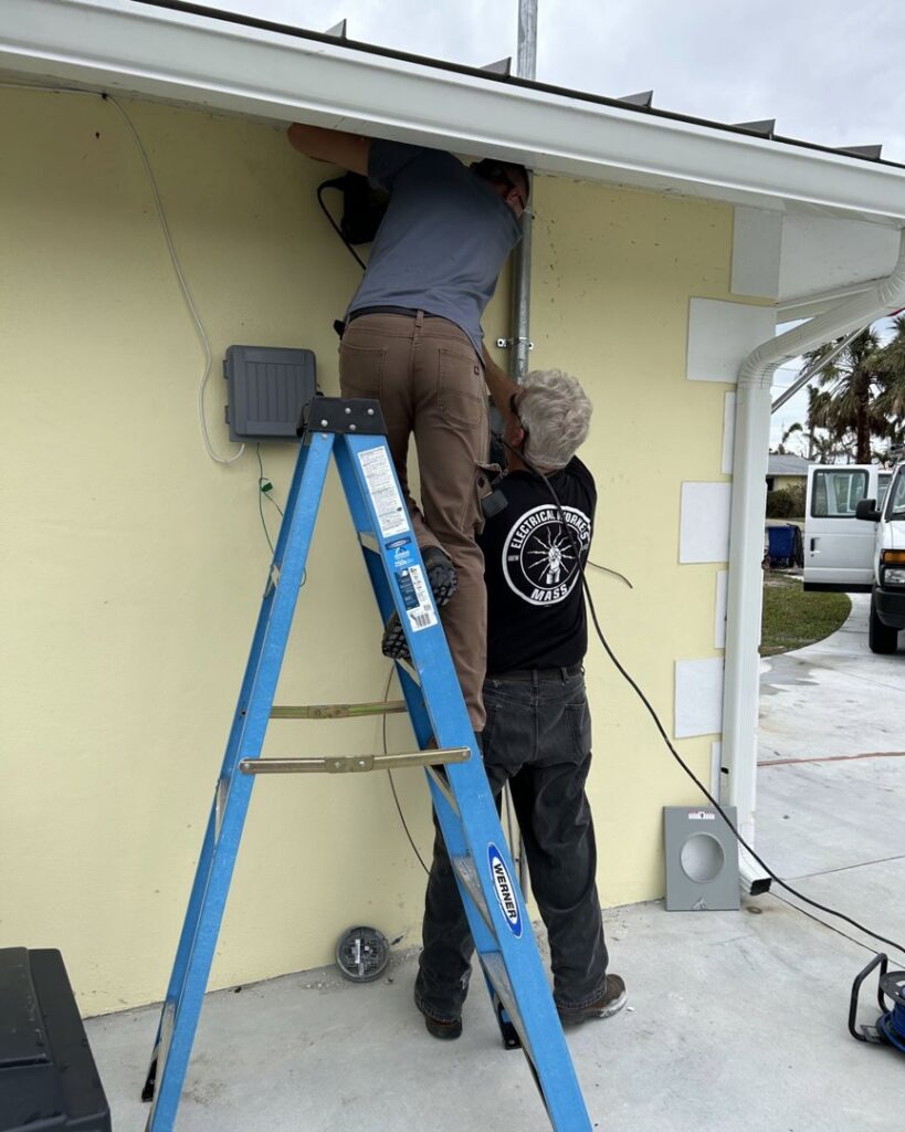 Electricians installing exterior electrical conduit and wiring for Sound Electric LLC in Saint James City, FL.