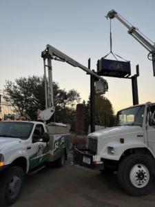 Electricians from R&R Electric, Inc. using boom trucks to install a large sign in Florissant, MO.
