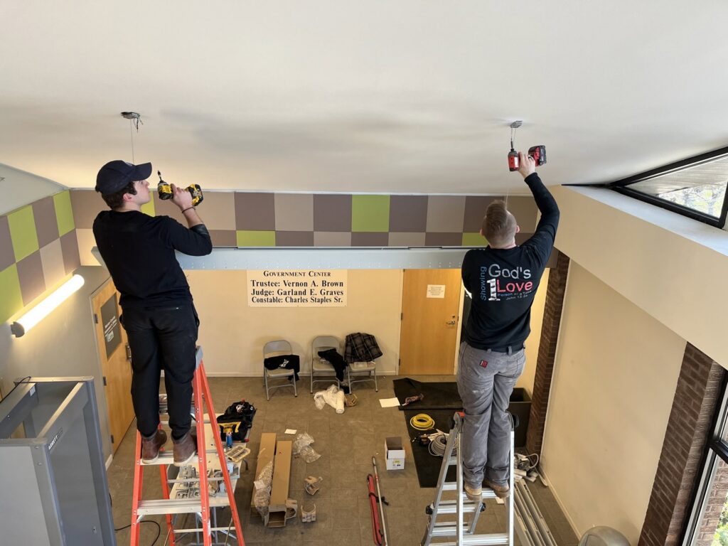 Two electricians from Zimmerman Electric Indy installing new light fixtures in a commercial building in Indianapolis, IN