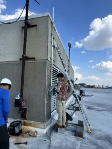 Electricians from Big City Lighting and Electric installing conduit on a commercial rooftop in Houston, TX.