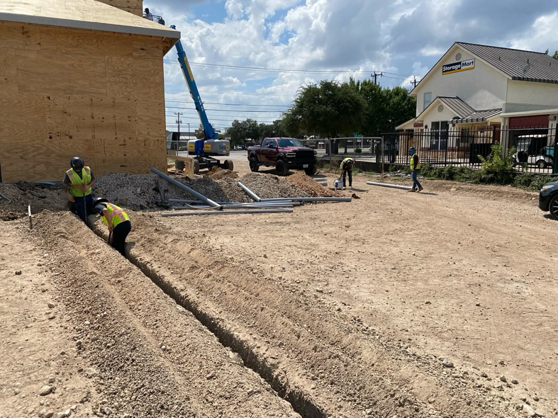 Electricians installing underground conduit for new electrical lines at a job site for Thundercolt Electric in San Antonio, TX.