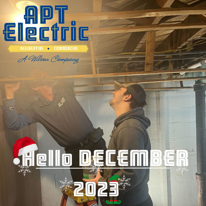 Two electricians from APT Electric installing wiring in a ceiling in Chesterland, OH.