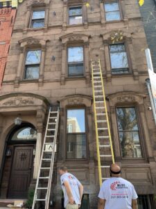 Electricians from Moss Contracting setting up ladders for a job on a building exterior in Philadelphia, PA.