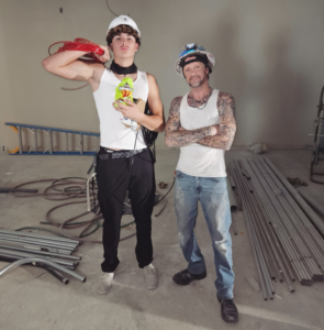 Two electricians from Reuben Electrical Contracting on a construction site, one holding electrical wire, in Scottsdale, AZ.