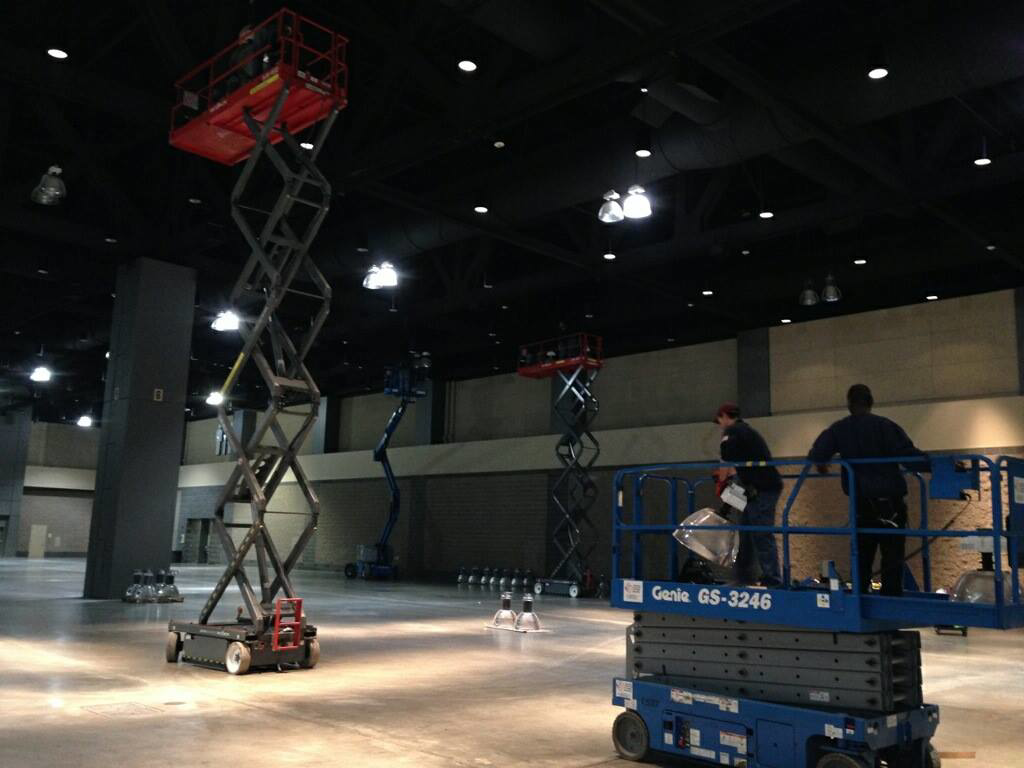 Electricians on scissor lifts installing or maintaining overhead lighting in a large commercial space by Pasquariello Electric Corporation in New Haven, CT.