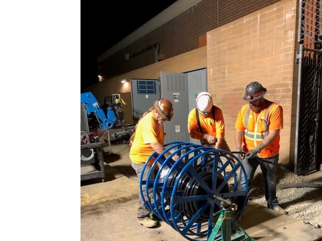High Tech Electric inc. electricians pulling large electrical cables from a spool during an installation project in Van Nuys, CA.