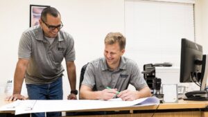 Efficient Electric electricians reviewing blueprints and plans for an electrical project in Canton, MI.