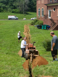 Electricians from Visual Electric, Inc. trenching for underground wiring near a residential property in Frederick, MD.