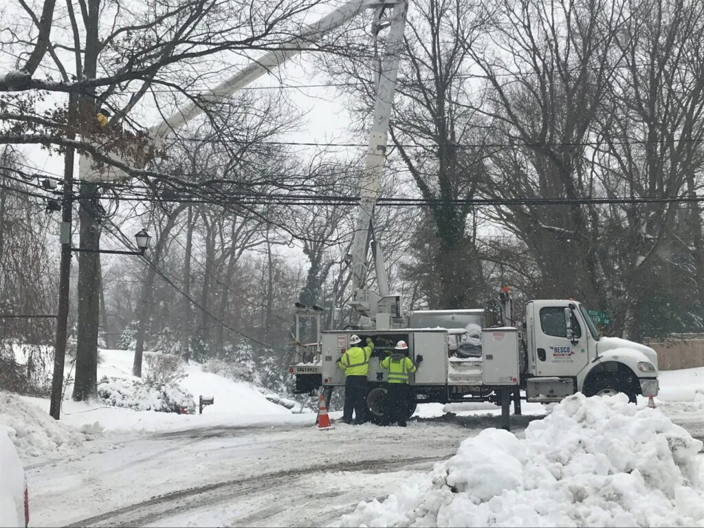 BESCO electricians with a utility truck on a snowy road, performing electrical work in Knoxville, TN.