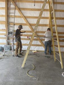 Two electricians from P.H. Electric performing wiring work in a commercial space in Soulsbyville, CA.