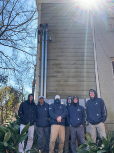 The Stroh Electrical team standing in front of an exterior electrical service installation on a building in Montgomery, AL.