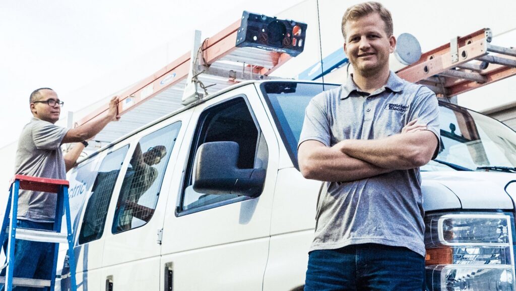 Two electricians from Efficient Electric with their service van and ladders, ready for a job in Canton, MI.