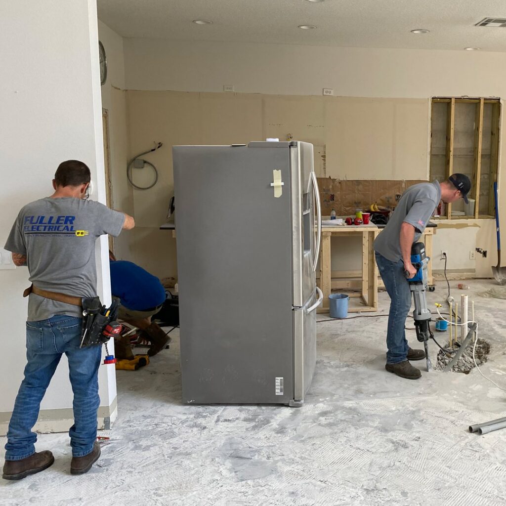 Electricians from Fuller Electrical Contractors, Inc. working on a construction site in Oldsmar, FL, installing new wiring.