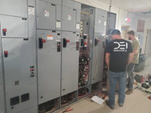 Electricians inspecting and working on a large electrical panel for Dobson Electric, Inc. in Jacksonville, FL.
