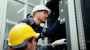 Two electricians working on an industrial electrical panel or machinery for Polk Electric, LLC in Rock Hill, SC