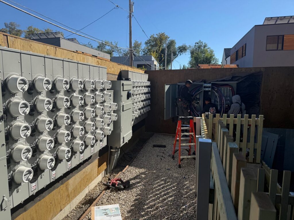 Electricians working on a large outdoor electrical meter bank installation for Goal Electric LLC in West Valley City, UT.