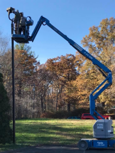 Electricians from 3C Electric Systems working on an outdoor light pole using a boom lift in Hartford, CT.