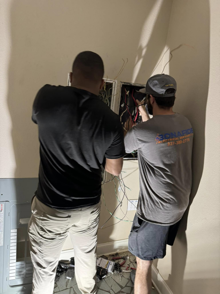 Two electricians from Bonafide Electrical Services working on an electrical panel in Denham Springs, LA.