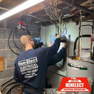 Two electricians from Henelect Electrical Contractors working on an electrical panel in Milford, NJ.