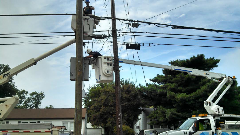 Two electricians from FLEX Electric working on power lines and utility poles in Virginia Beach, VA.