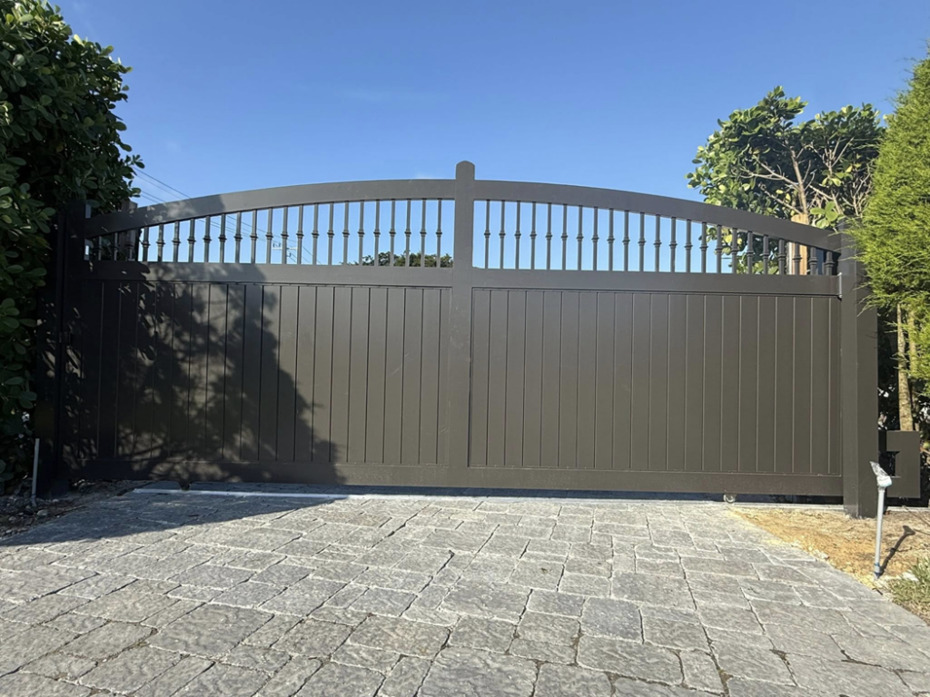 An elegant arched driveway gate showcasing quality craftsmanship by A Master Work Corp. in Hialeah, FL.