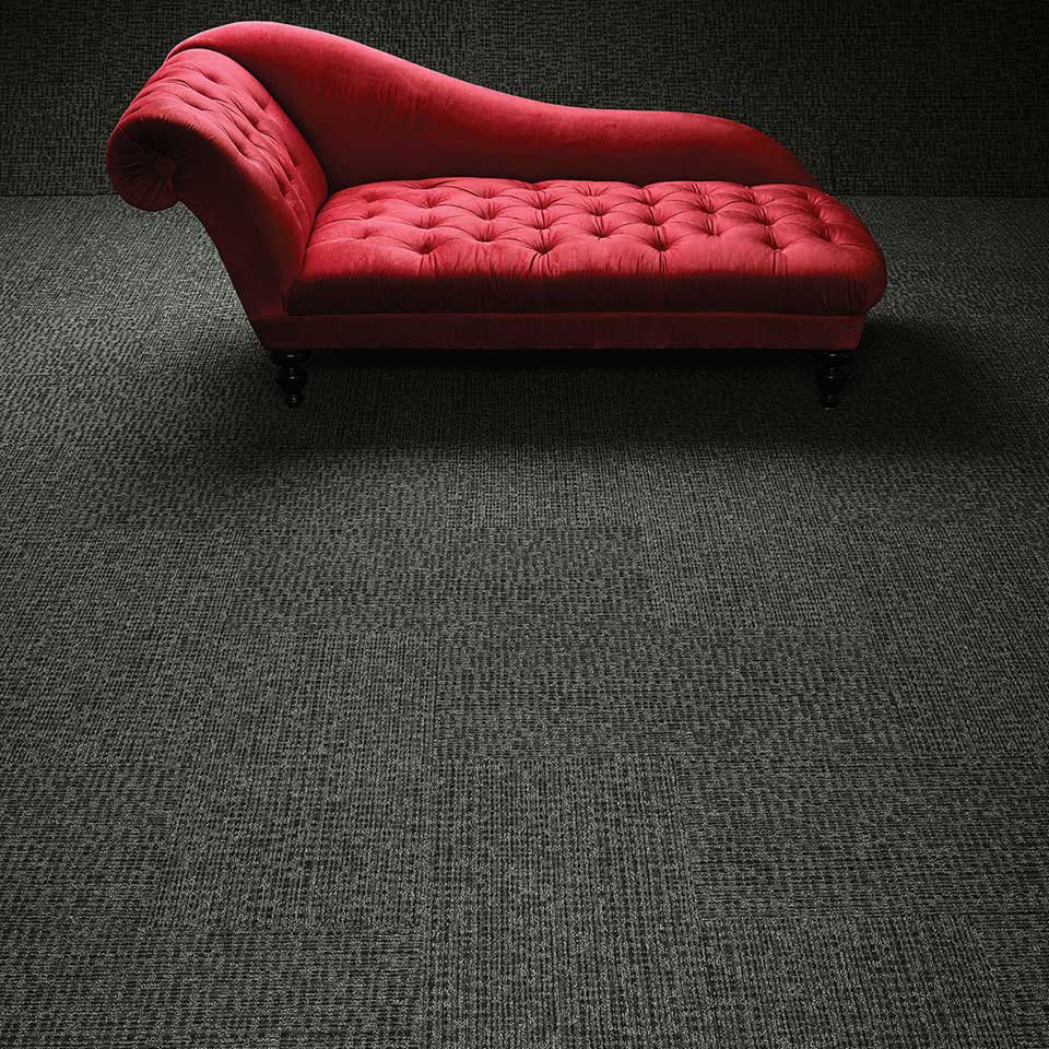 An elegant room with a red chaise lounge and dark grey patterned carpet, a professional installation by Eastpointe Interiors in Caledonia, MI.