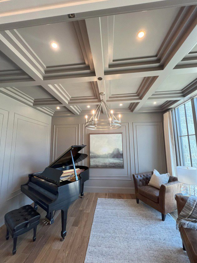 An elegant room with a grand piano, showcasing a chandelier and recessed lighting installed by Homestead Electric in Orem, UT.