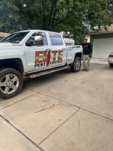 An Elite Pest Control technician standing proudly next to their service truck in Maple Grove, MN.