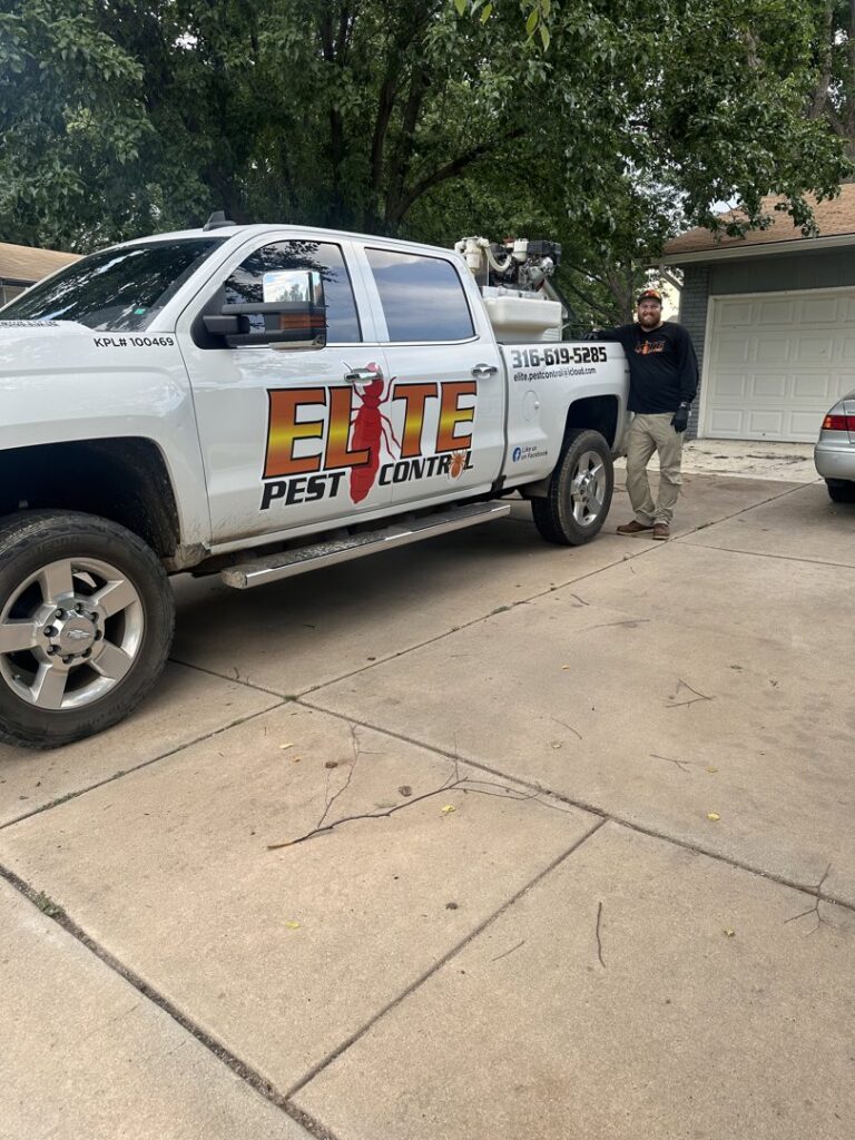 An Elite Pest Control technician standing proudly next to their service truck in Maple Grove, MN.