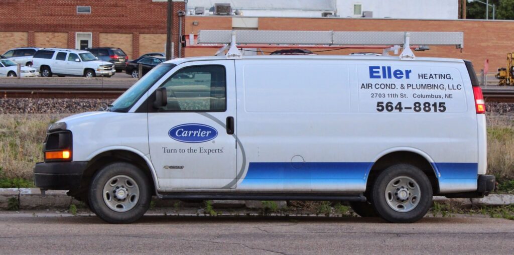 A white Eller Heating & Air Conditioning LLC service van with a ladder rack in Columbus, NE, ready for HVAC jobs.