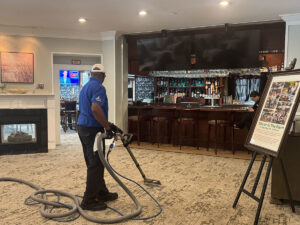 An employee from Get Steamed Carpet Cleaning, Inc. cleaning a large area rug in a commercial space in North Charleston, SC.