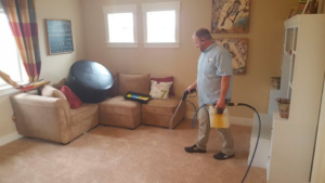 An employee of Carpet Clean Team actively cleaning a residential carpet in Meridian, ID.