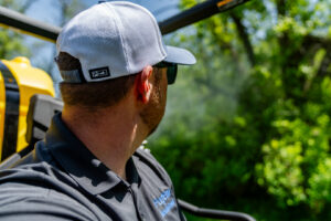 An employee of Fog'em Mosquito Control spraying mosquito treatment from a utility vehicle in Bismarck, ND.