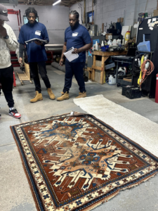 Employees inspecting an oriental rug on the floor at Thomas Carpet & Oriental Rug Cleaners in Newtown Square, PA