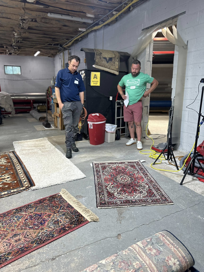 Employees with several oriental rugs laid out on the floor at Thomas Carpet & Oriental Rug Cleaners in Newtown Square, PA