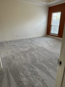 An empty bedroom with newly installed light gray carpet by Carpet World Baton Rouge, LA.