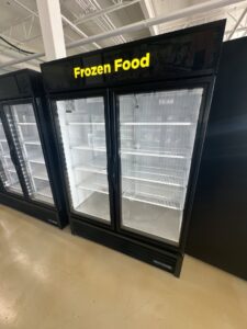 An empty commercial frozen food display freezer, representing equipment serviced by Setpoint Refrigeration LLC in Liberty Hill, TX